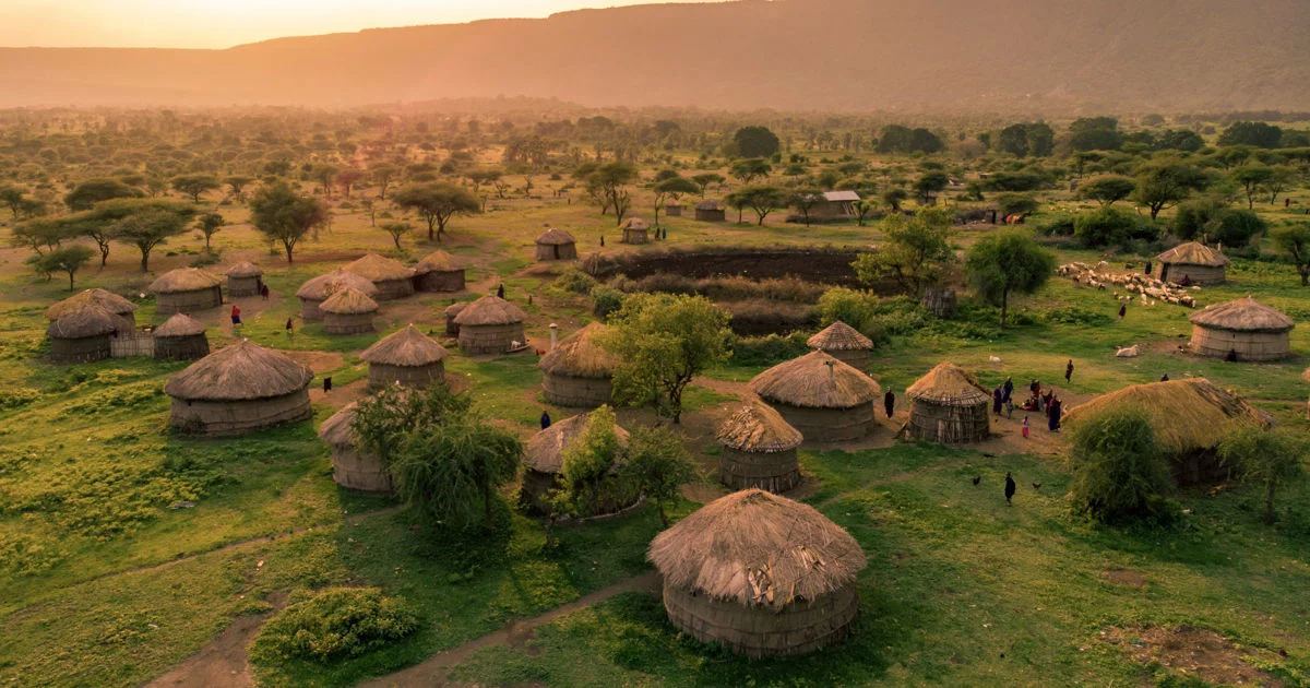Traditional thatched homesteads on the grassland plains near Boma National Park at sunset